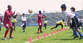 Ecuador team members give soccer tips to Japanese children